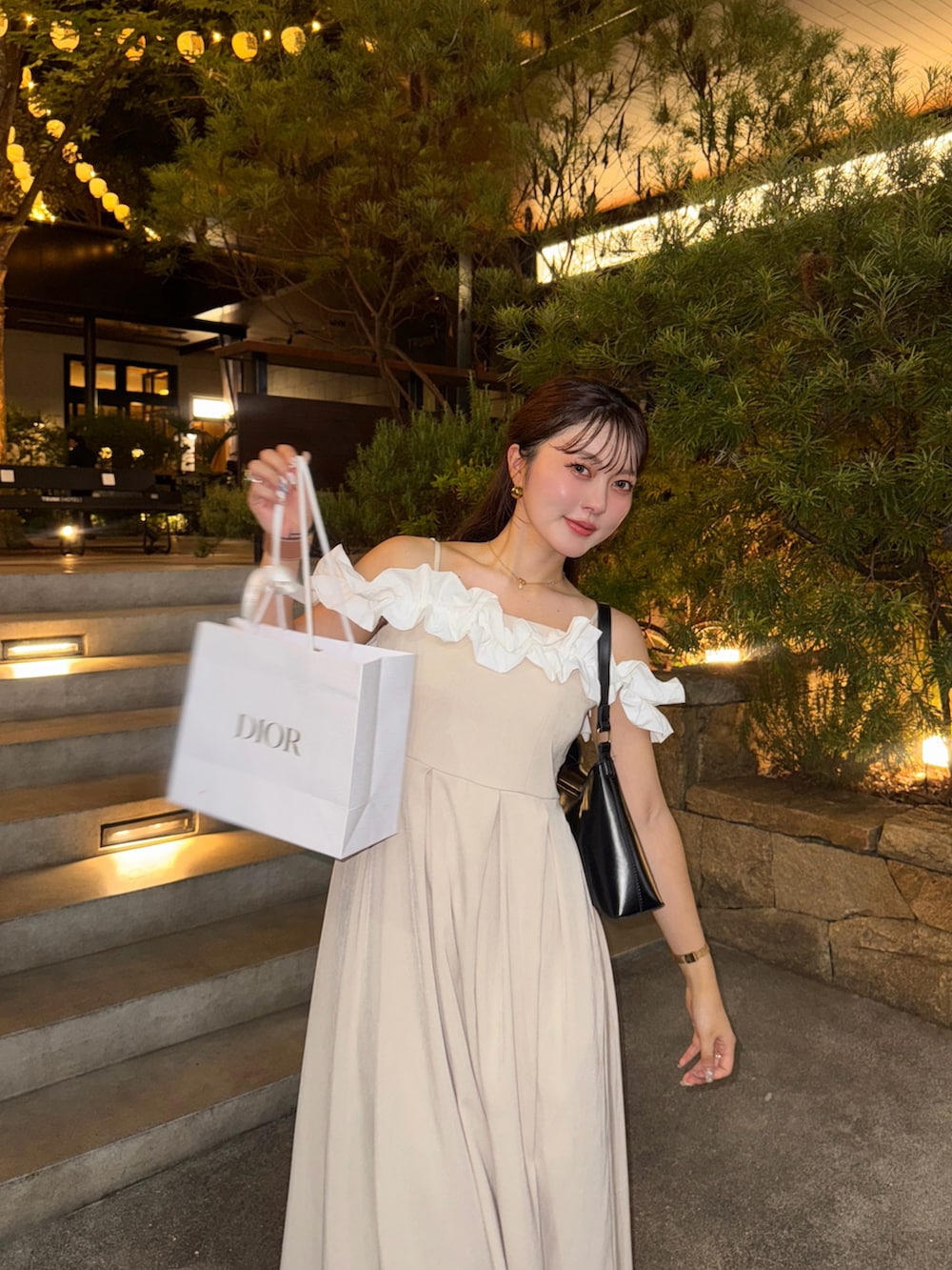 ブラック系のドレス、ブラウン系のサンダル、ブラック系のハンドバッグを着用したレディースの夏コーディネートの4枚目の写真