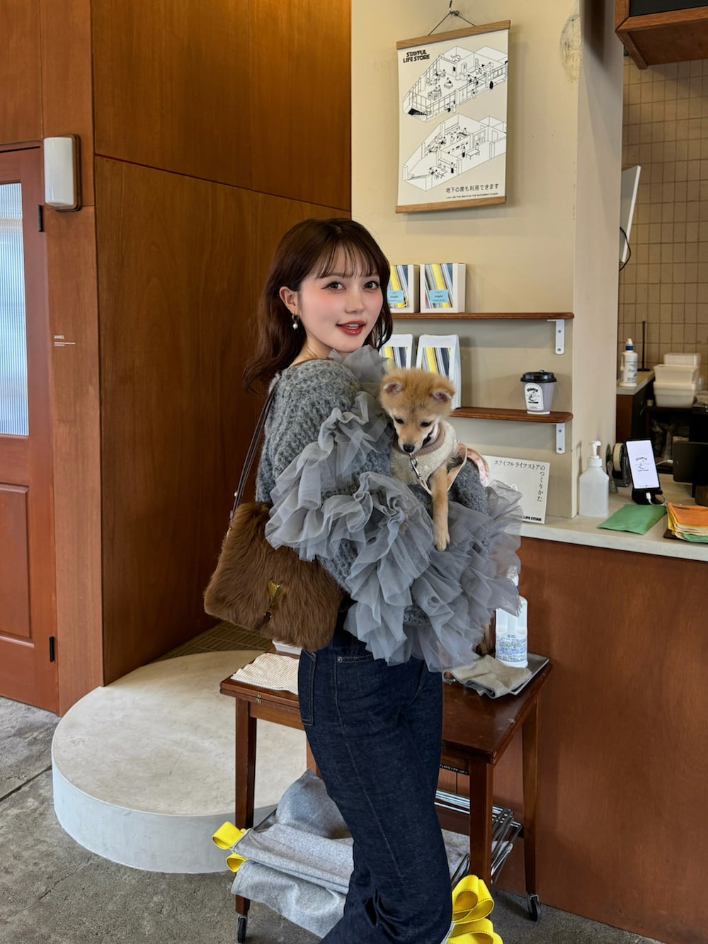 グレー系のニット/セーター、ブルー系のデニムパンツを着用したレディースの春コーディネートの3枚目の写真