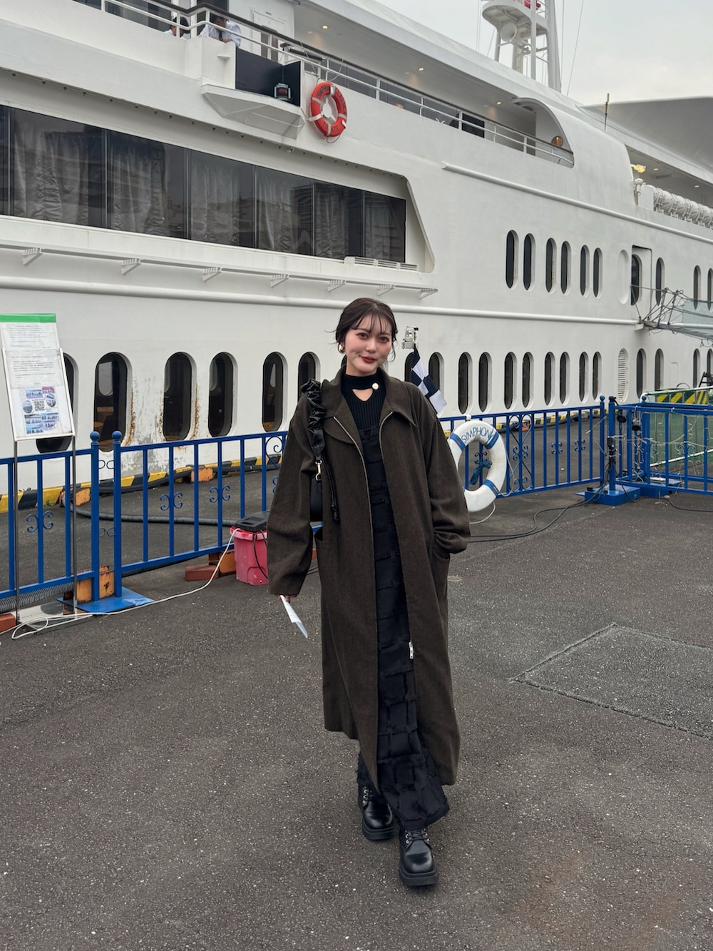 ブラック系のニット/セーター、ブラウン系のハンドバッグを着用したレディースの秋コーディネートの2枚目の写真