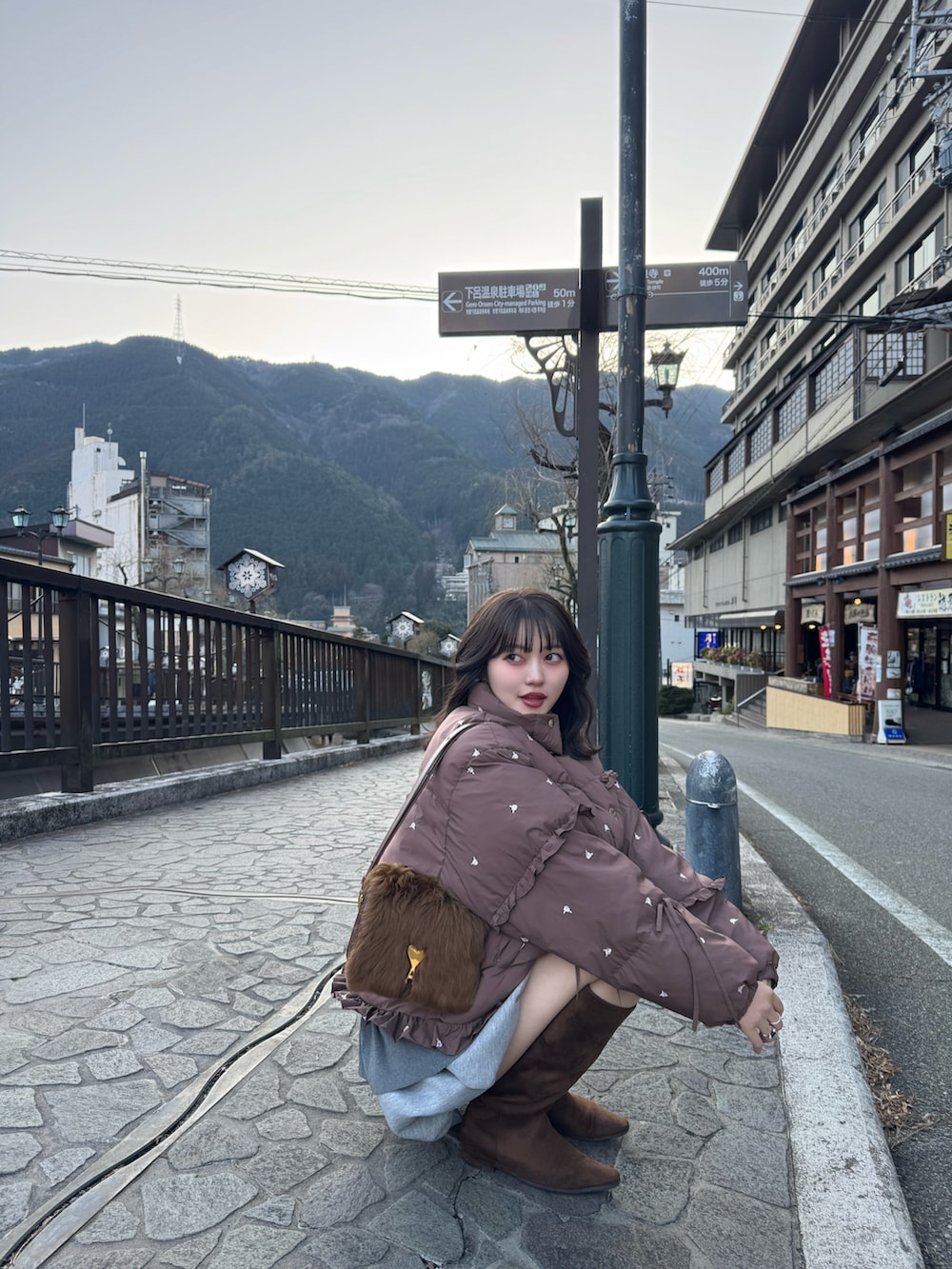 グレー系のスカート、ブラウン系のブーツを着用したレディースの冬コーディネートの3枚目の写真