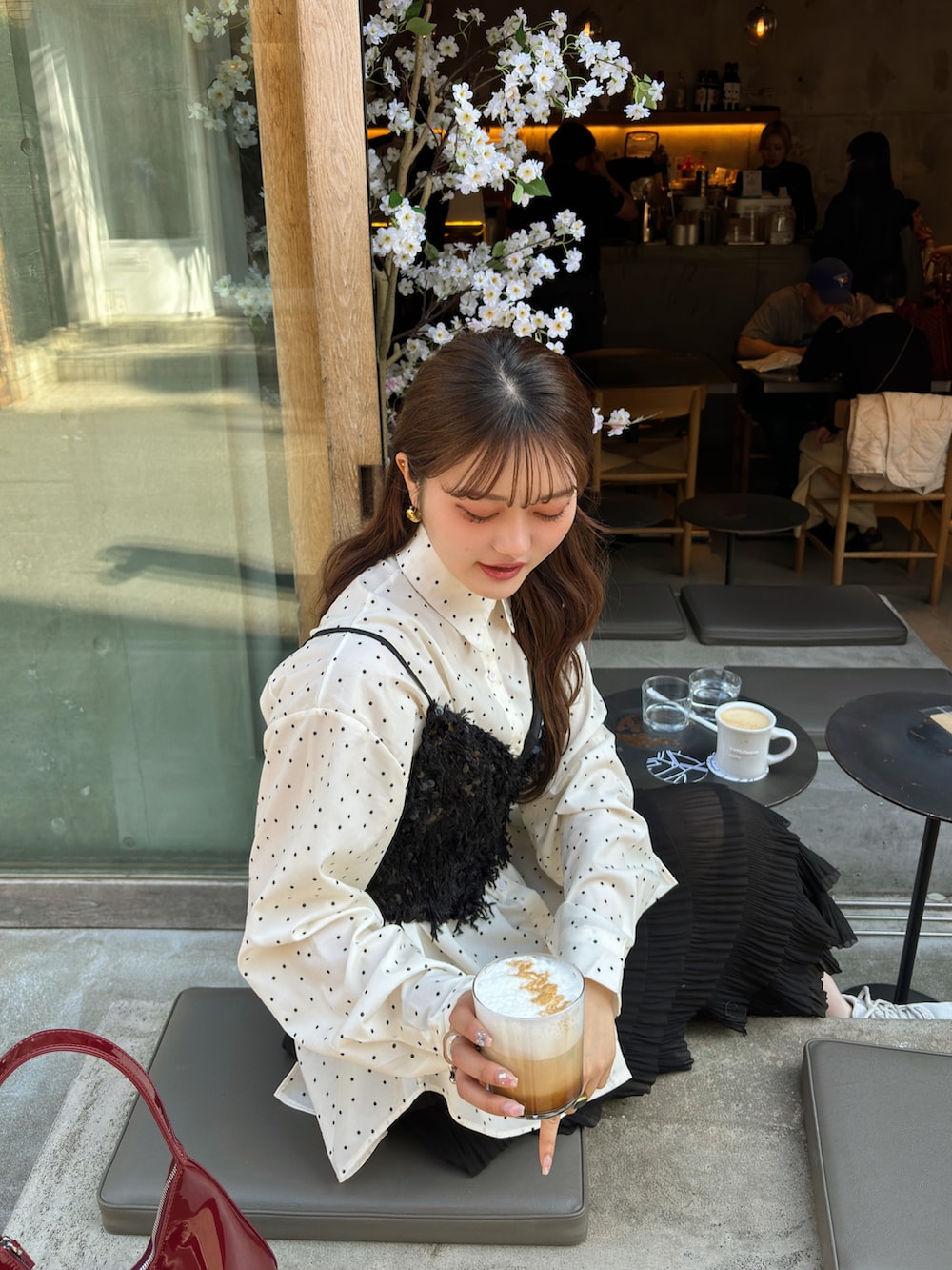 ホワイト系のシャツ/ブラウス、レッド系のハンドバッグ、ブラック系のスカートを着用したレディースの春コーディネートの3枚目の写真