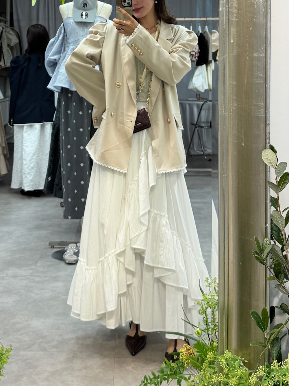 ホワイト系のスカート、ベージュ系のテーラードジャケット、レッド系のパンプスを着用したレディースの冬コーディネートの3枚目の写真