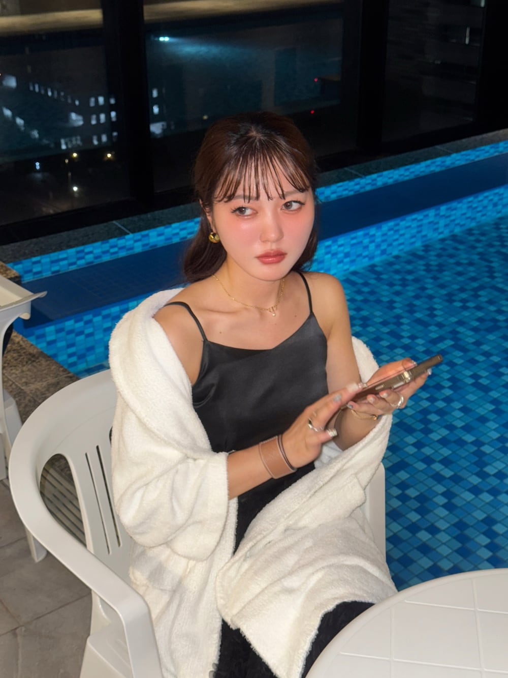 ブラウン系のショルダーバッグ、ブラック系のドレス、シルバー系のパンプスを着用したレディースの夏コーディネートの4枚目の写真