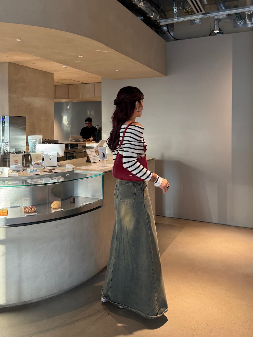 ベージュ系のTシャツ/カットソー、ブルー系のデニムスカートを着用したレディースの秋コーディネートの2枚目の写真