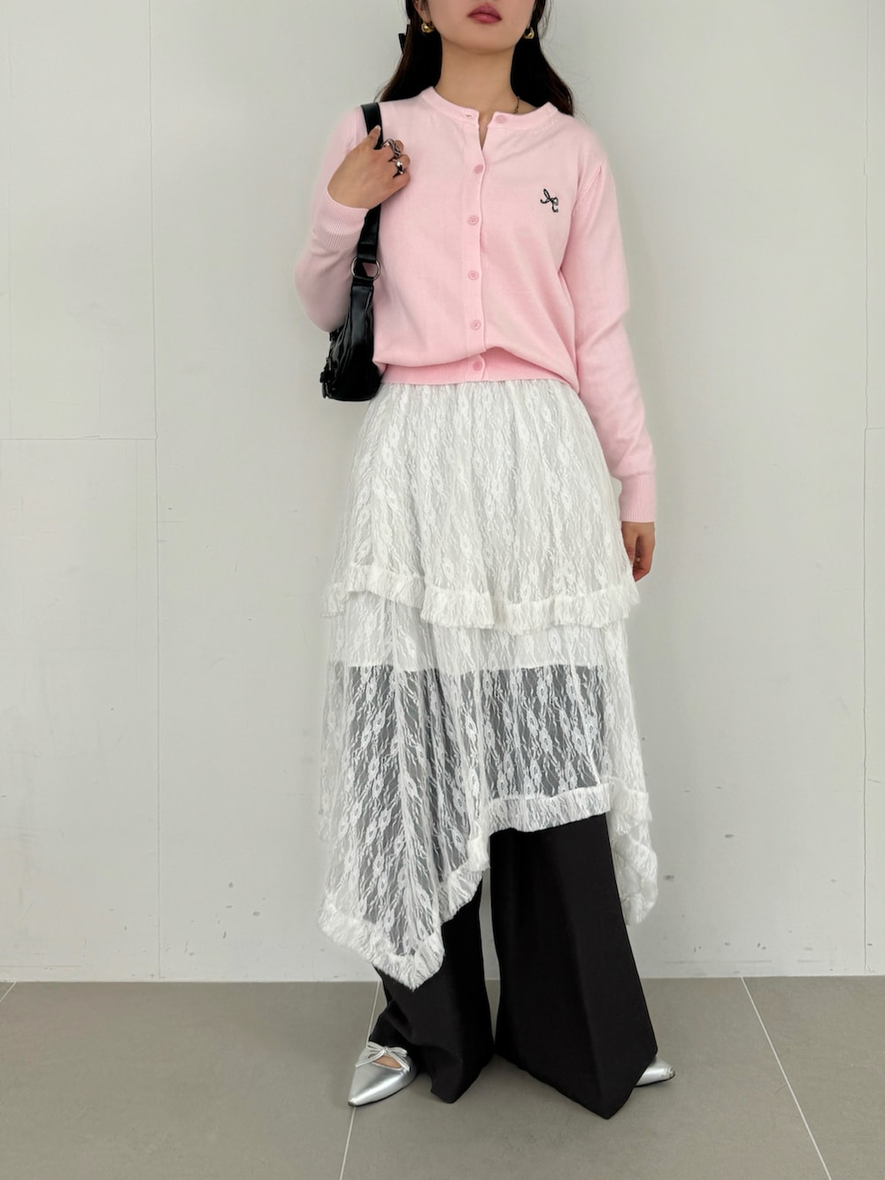 ホワイト系のスカート、ピンク系のカーディガン/ボレロ、ブラウン系のショルダーバッグを着用したレディースの春コーディネートの3枚目の写真