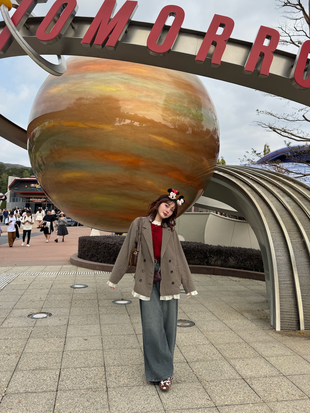 ブラウン系のテーラードジャケット、ブルー系のデニムパンツ、ブラウン系のスニーカーを着用したレディースの冬コーディネートの4枚目の写真