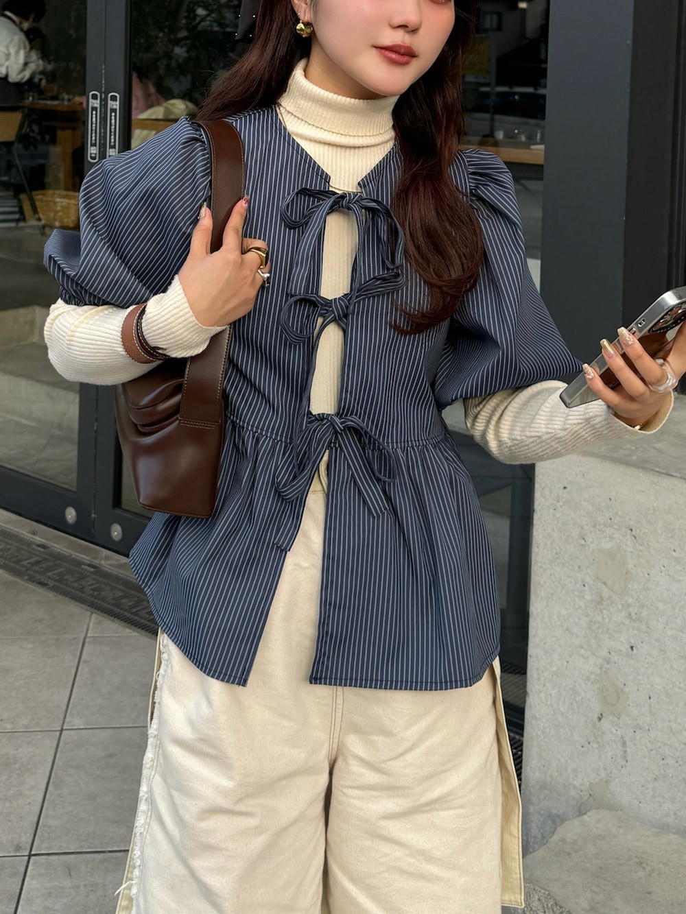 グリーン系のシャツ/ブラウス、ベージュ系のスニーカーを着用したレディースの春コーディネートの3枚目の写真