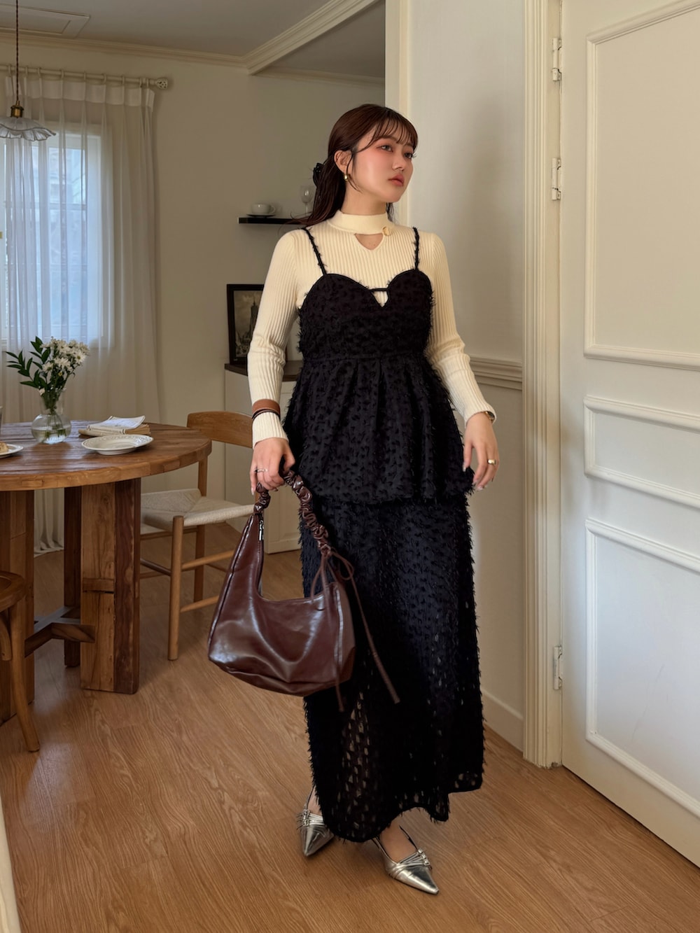 ベージュ系のニット/セーター、ブラック系のTシャツ/カットソー、ブラック系のスカートを着用したレディースの春コーディネートの5枚目の写真