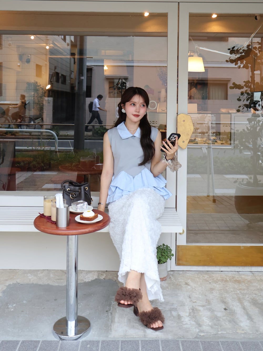 グレー系のシャツ/ブラウス、ブラック系のスカート、ブラウン系のサンダルを着用したレディースの夏コーディネートの2枚目の写真