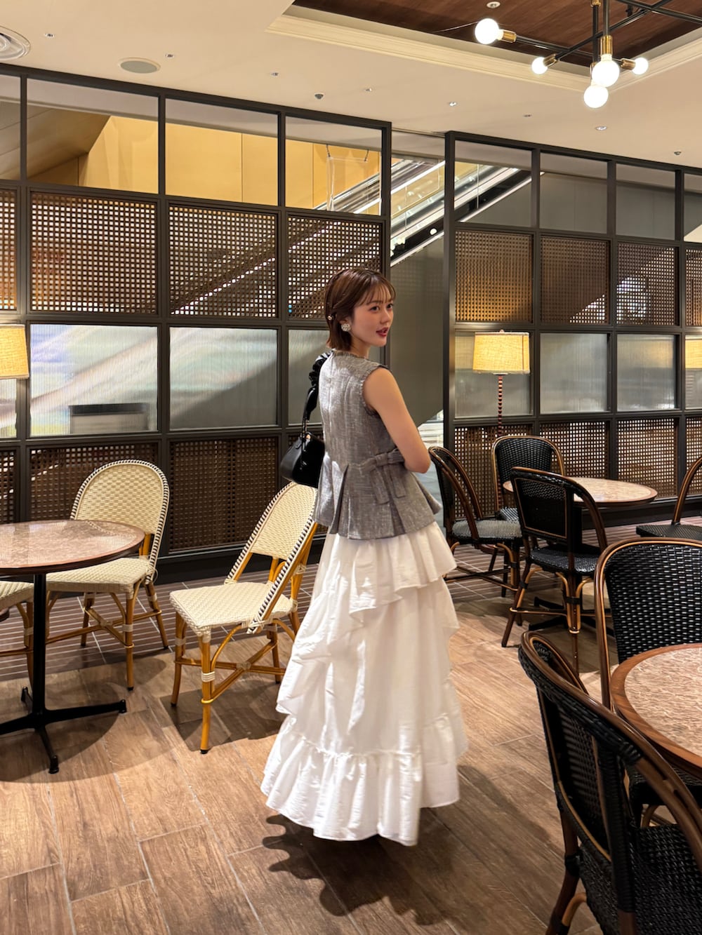 ホワイト系のスカート、ブラック系のシャツ/ブラウス、ブラック系のサンダルを着用したレディースの春コーディネートの5枚目の写真