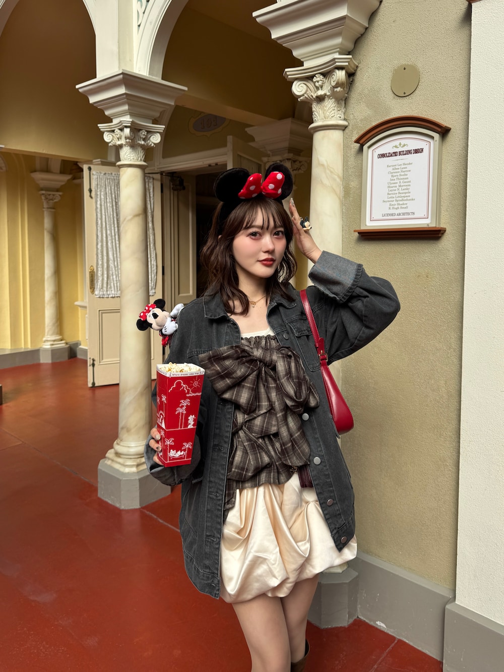 ブラック系のデニムジャケット、ブラウン系のキャミソール、ブラウン系のブーツを着用したレディースの春コーディネートの4枚目の写真