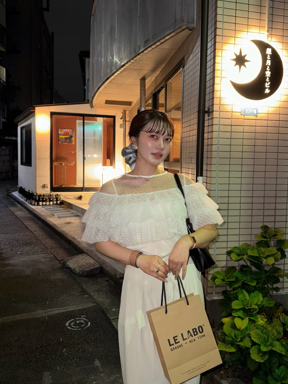 ホワイト系のシャツ/ブラウス、シルバー系のパンプス、ブラック系のハンドバッグを着用したレディースの夏コーディネートの3枚目の写真