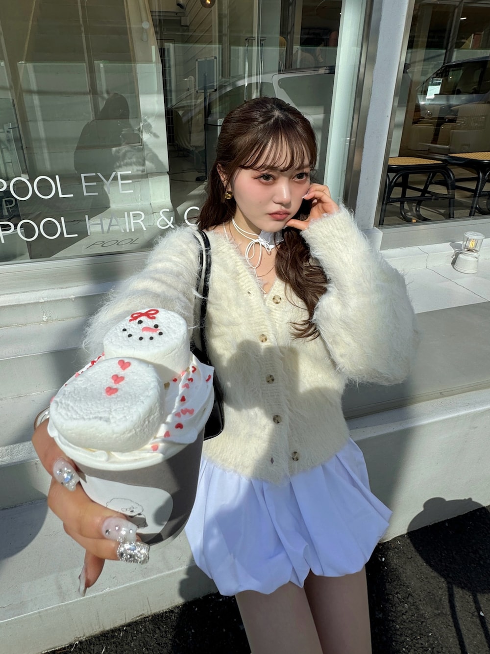 ホワイト系のスカート、ベージュ系のカーディガン/ボレロを着用したレディースの冬コーディネートの2枚目の写真