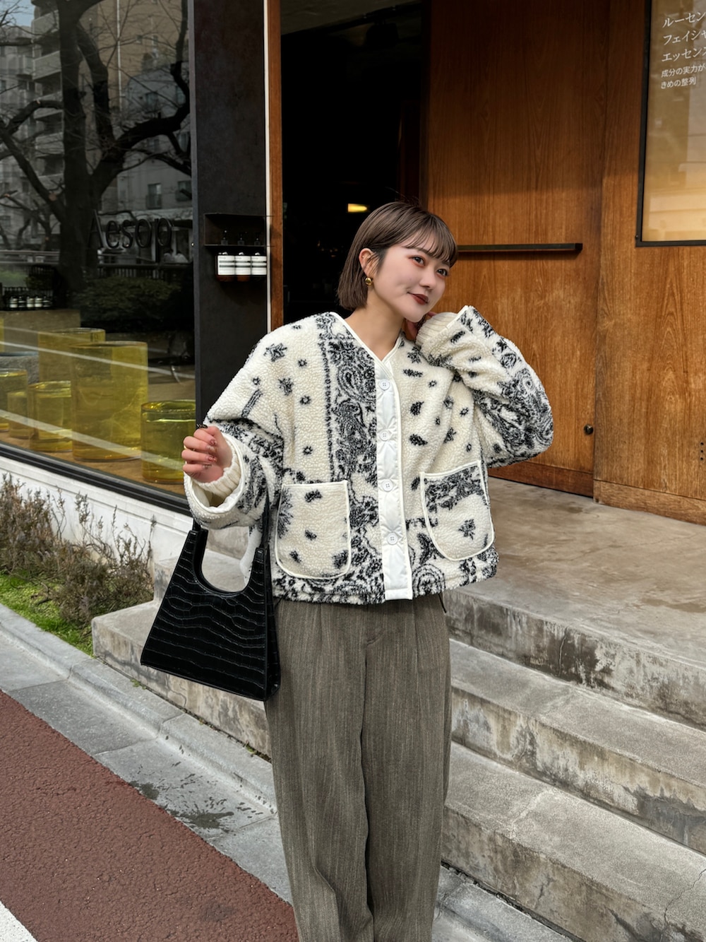 ブラウン系のパンツ、ホワイト系のタンクトップを着用したレディースの冬コーディネートの4枚目の写真