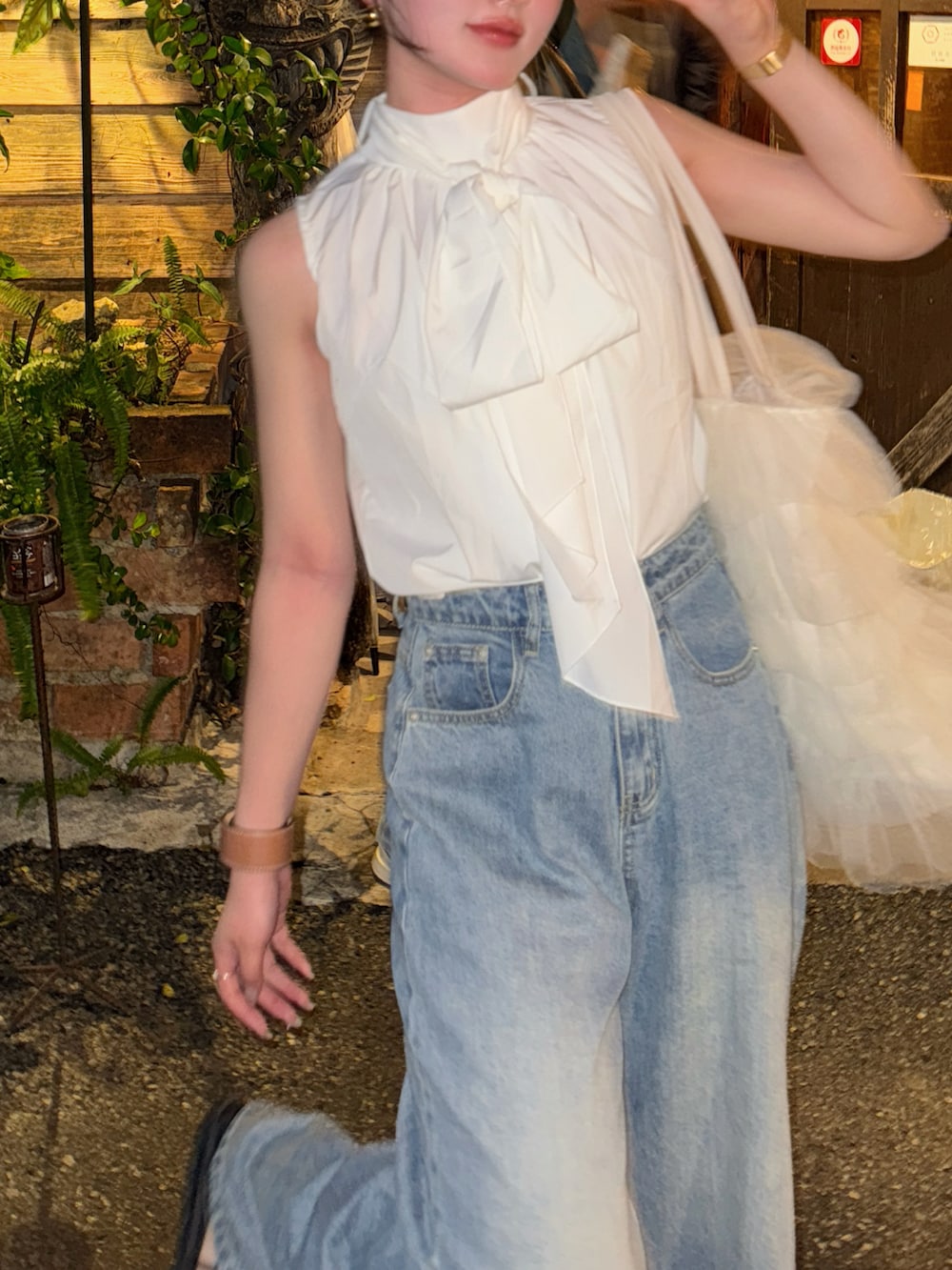 ブラック系のトートバッグ、ホワイト系のトップスを着用したレディースの春コーディネートの3枚目の写真