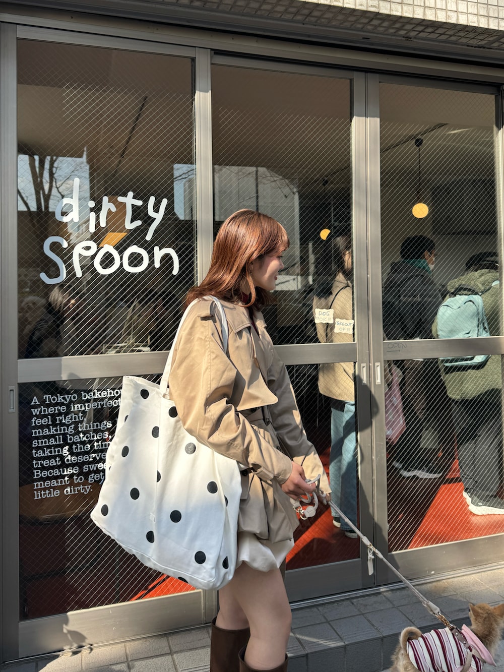 ベージュ系のトレンチコート、レッド系のニット/セーター、ブラウン系のブーツを着用したレディースの春コーディネートの2枚目の写真