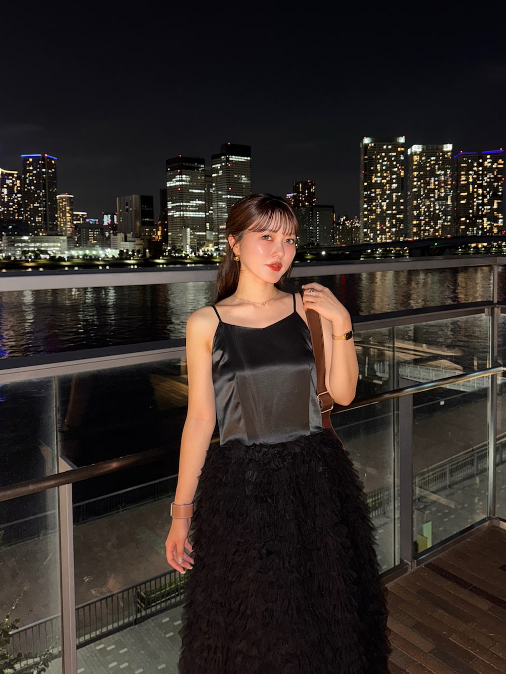 ブラウン系のショルダーバッグ、ブラック系のドレス、シルバー系のパンプスを着用したレディースの夏コーディネートの2枚目の写真