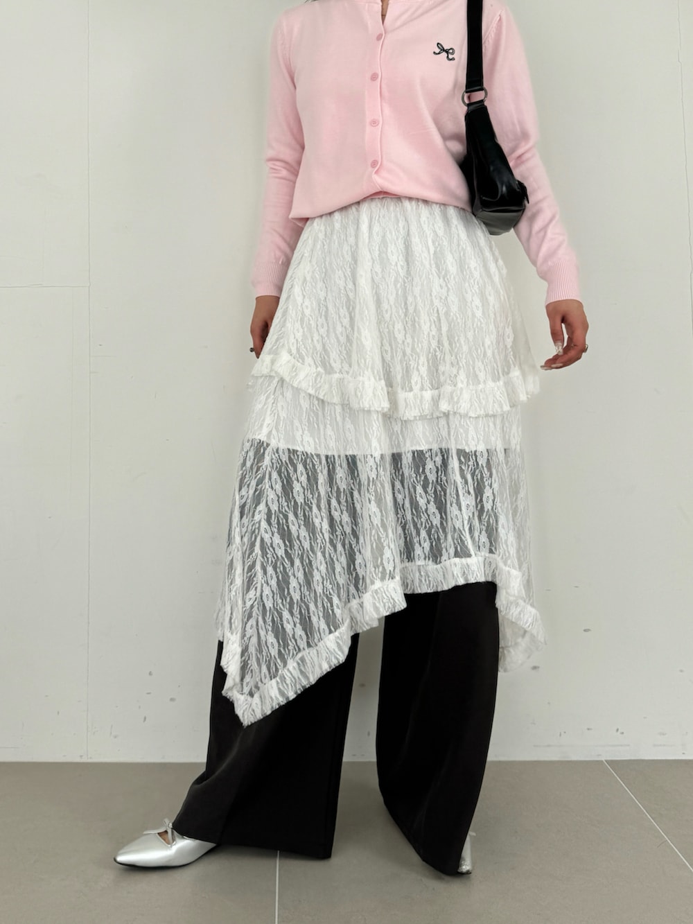 ホワイト系のスカート、ピンク系のカーディガン/ボレロ、ブラウン系のショルダーバッグを着用したレディースの春コーディネートの5枚目の写真