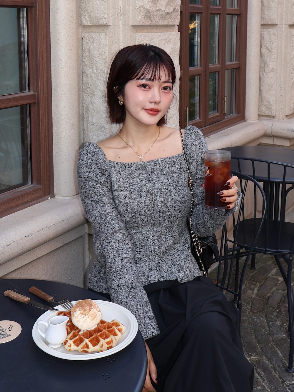 ブラック系のスカート、ブラック系のパンプスを着用したレディースの秋コーディネートの2枚目の写真