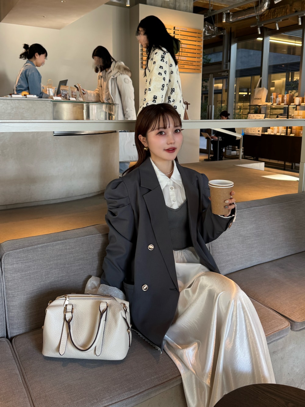 ホワイト系のスカート、ホワイト系のボストンバッグ、グレー系のテーラードジャケットを着用したレディースの春コーディネートの5枚目の写真