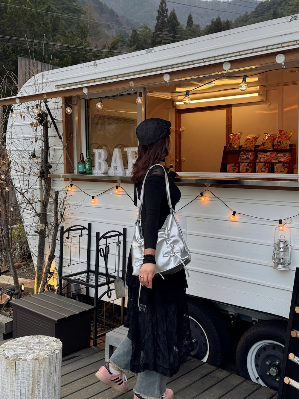 ブラック系のスカート、ブルー系のデニムパンツ、ブラック系のTシャツ/カットソーを着用したレディースの春コーディネートの2枚目の写真