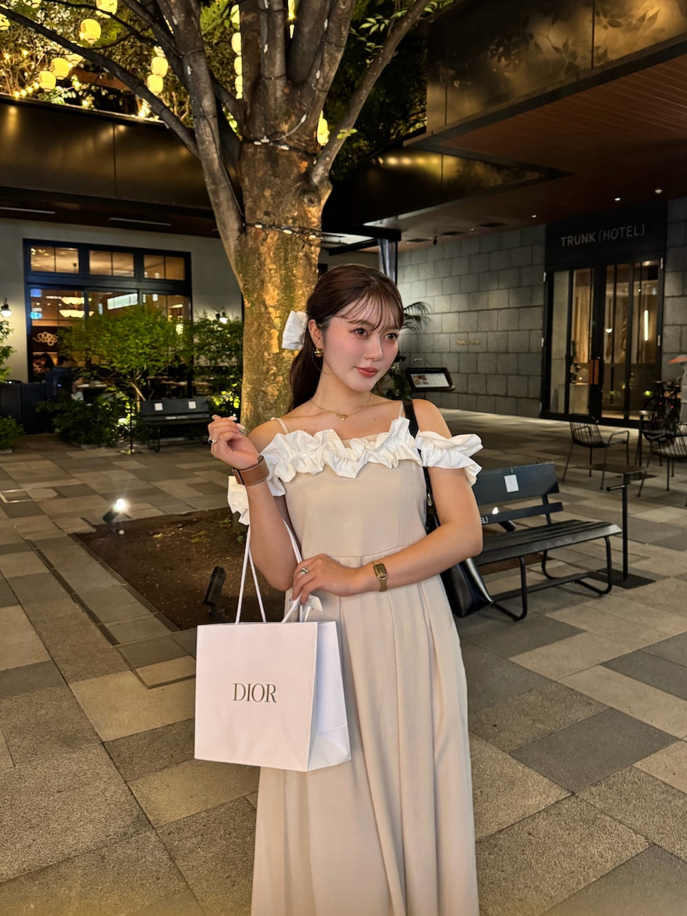 ブラック系のドレス、ブラウン系のサンダル、ブラック系のハンドバッグを着用したレディースの夏コーディネートの2枚目の写真