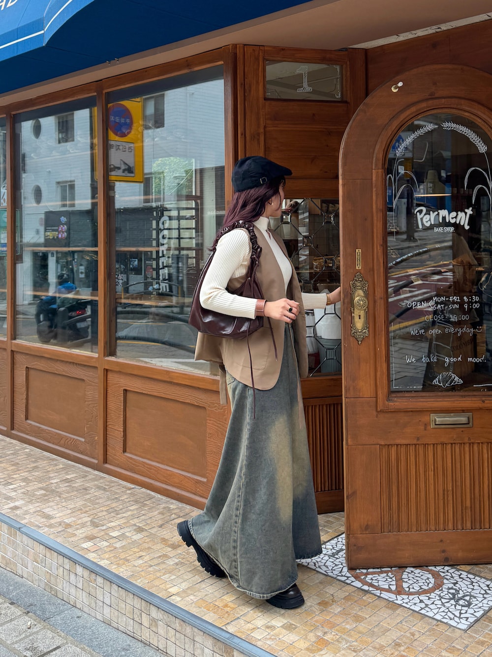 ブルー系のデニムスカート、ベージュ系のニット/セーター、ベージュ系のベストを着用したレディースの秋コーディネートの3枚目の写真