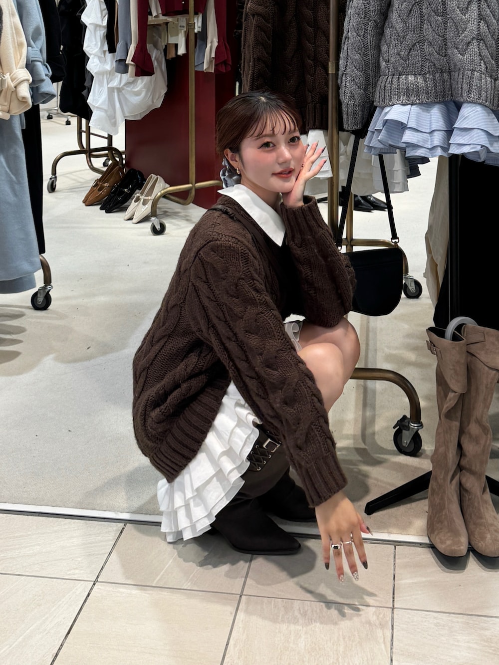 ブラウン系のボストンバッグ、ブラウン系のブーツを着用したレディースの秋コーディネートの2枚目の写真