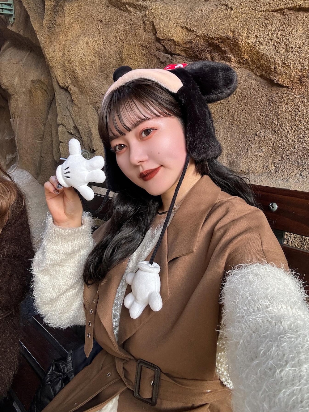 ブラウン系のトレンチコート、ホワイト系のその他トップス、ブラック系のブーツを着用したレディースの冬コーディネートの3枚目の写真