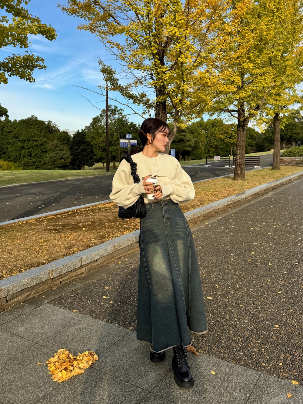 ブラウン系のハンドバッグ、ホワイト系のカーディガン/ボレロを着用したレディースの秋コーディネートの4枚目の写真