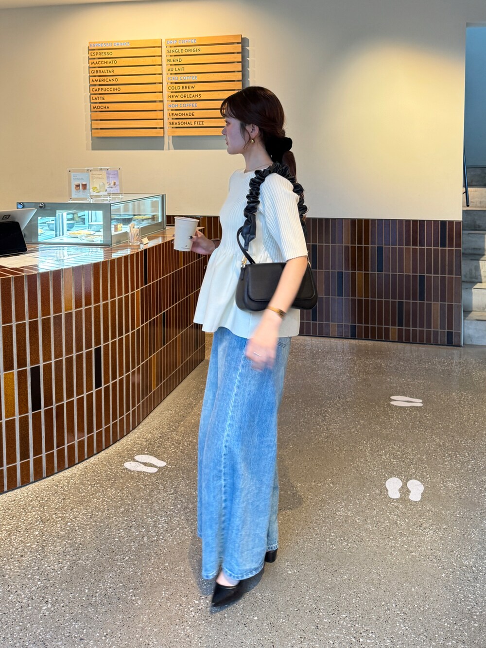 ホワイト系のニット/セーター、ブラック系のパンプスを着用したレディースの夏コーディネートの3枚目の写真