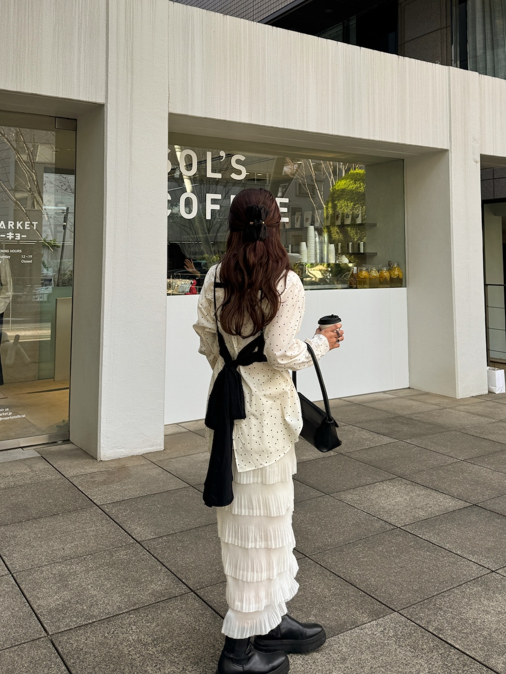 ブラック系のハンドバッグ、ブラック系のトップス、ホワイト系のシャツ/ブラウスを着用したレディースの冬コーディネートの5枚目の写真