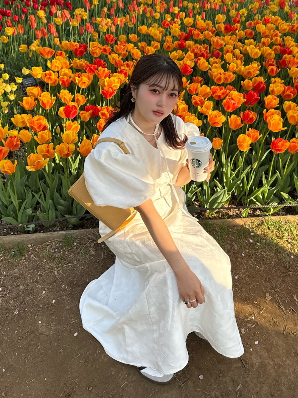 ホワイト系のワンピースを着用したレディースの春コーディネートの2枚目の写真