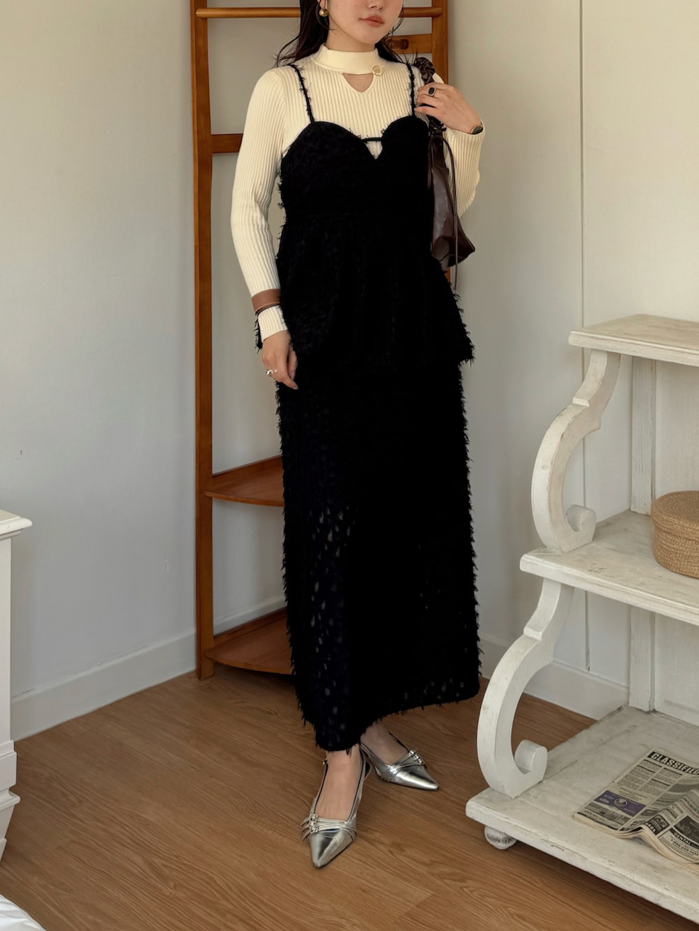 ベージュ系のニット/セーター、ブラック系のTシャツ/カットソー、ブラック系のスカートを着用したレディースの春コーディネートの2枚目の写真