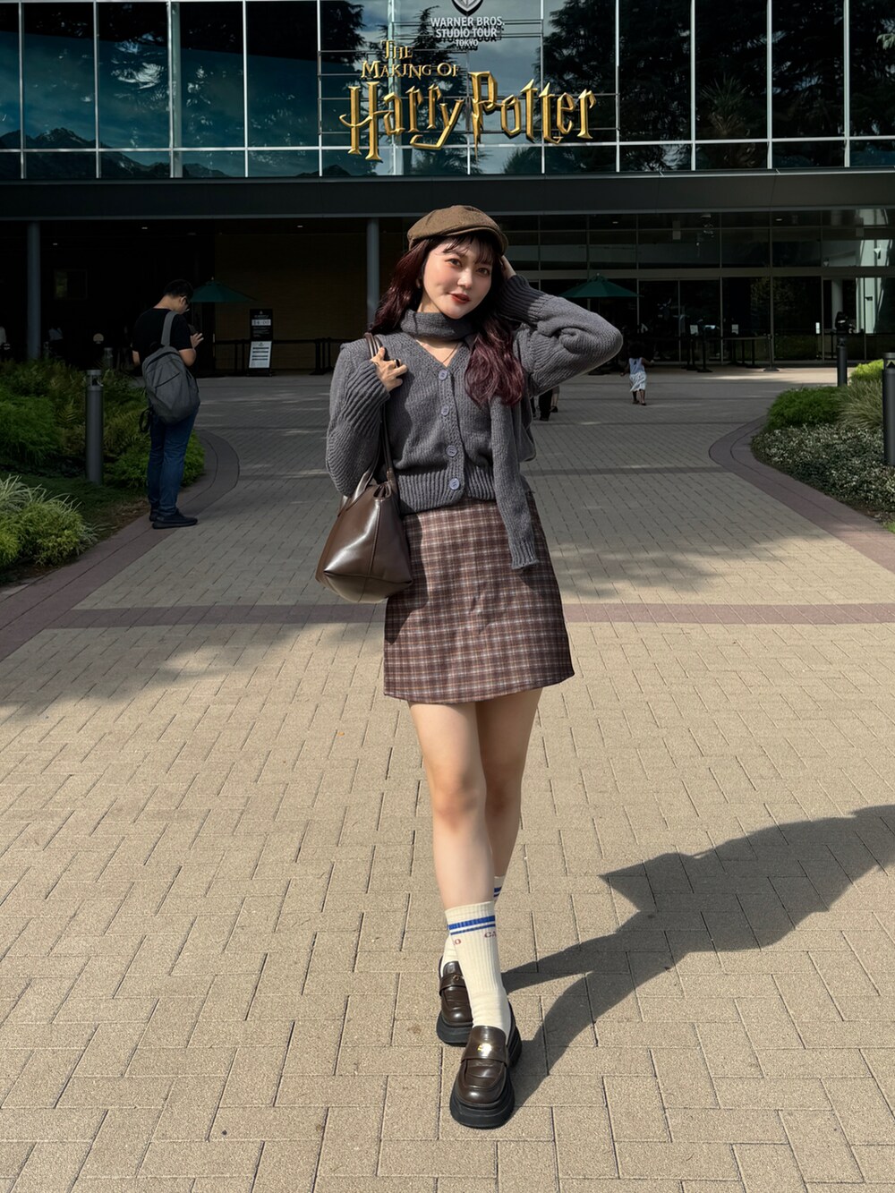 グレー系のニット/セーター、ブラウン系のスカートを着用したレディースの秋コーディネートの5枚目の写真