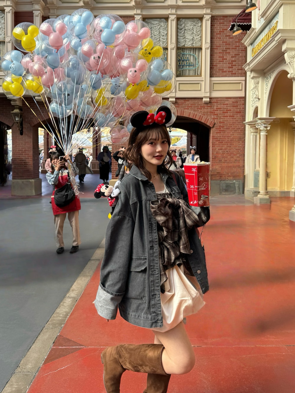 ブラック系のデニムジャケット、ブラウン系のキャミソール、ブラウン系のブーツを着用したレディースの春コーディネートの2枚目の写真