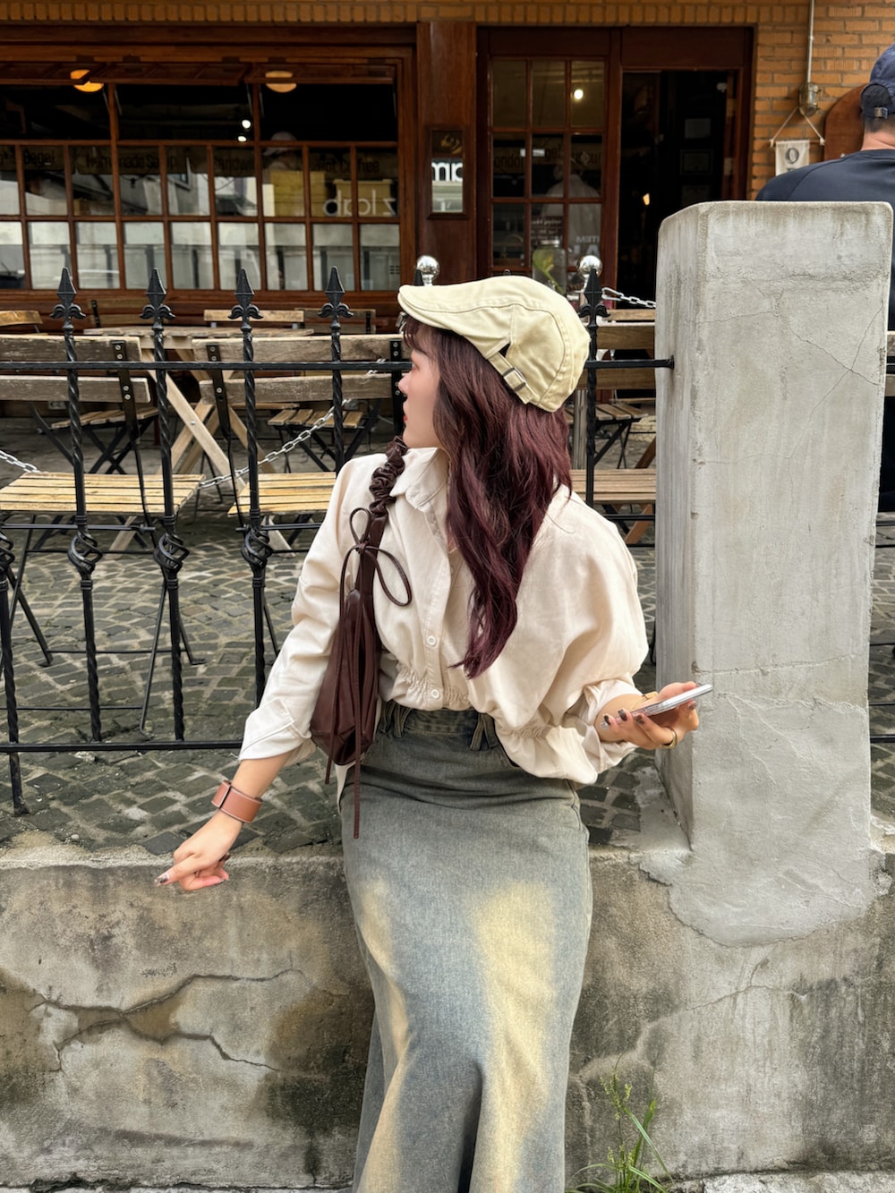 ベージュ系のシャツ/ブラウス、ブラウン系のハンドバッグ、ベージュ系のTシャツ/カットソーを着用したレディースの秋コーディネートの2枚目の写真