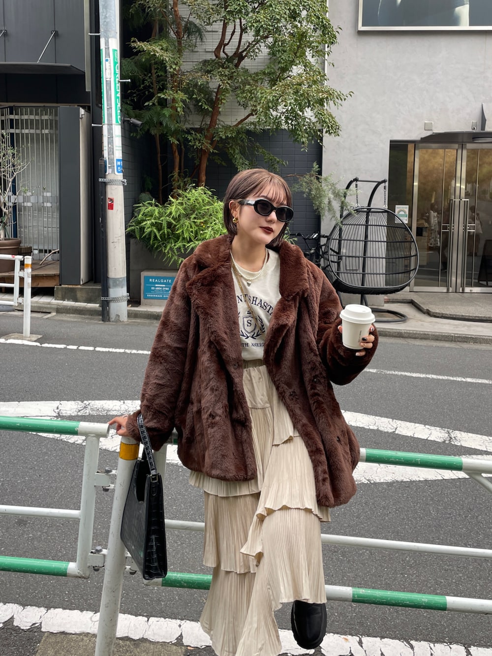 ブラック系のブーツ、ブラウン系のその他アウターを着用したレディースの春コーディネートの5枚目の写真