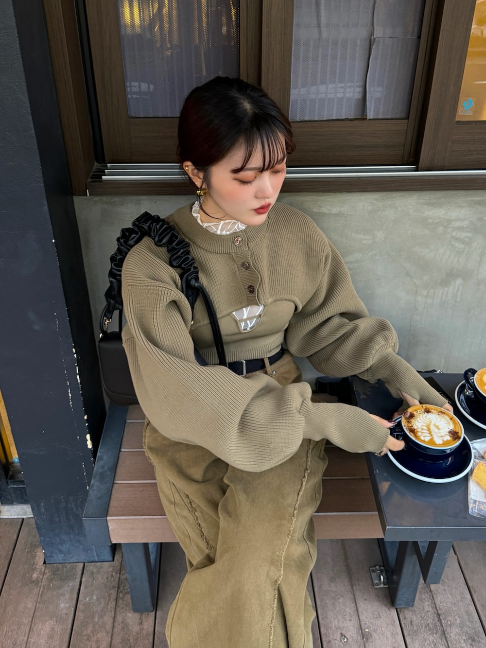 ホワイト系のカーディガン/ボレロ、ブラウン系のハンドバッグを着用したレディースの秋コーディネートの3枚目の写真