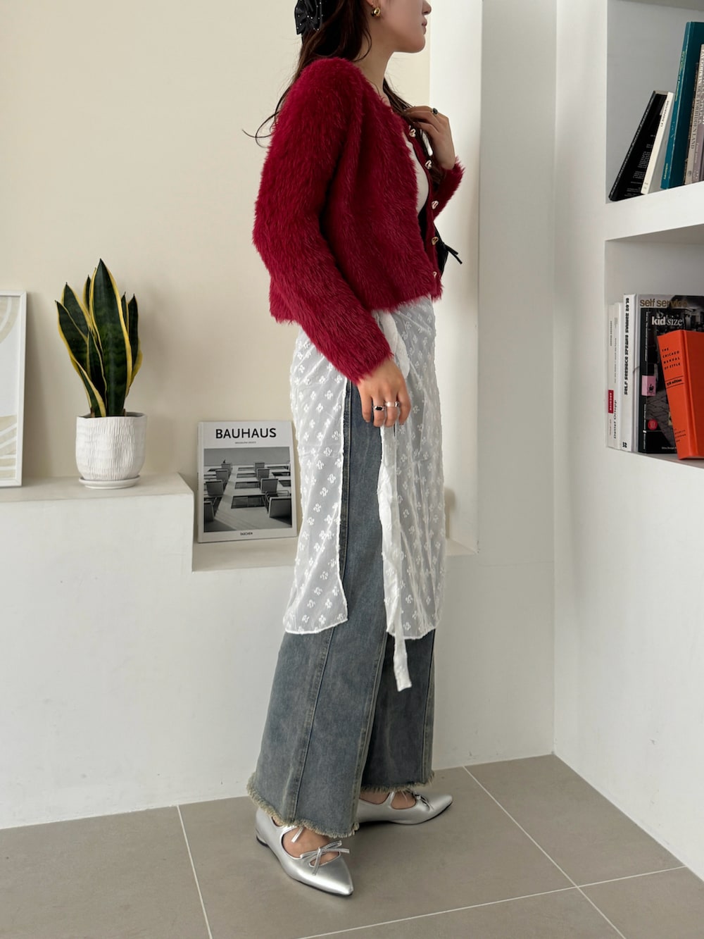 レッド系のカーディガン/ボレロを着用したレディースの冬コーディネートの2枚目の写真