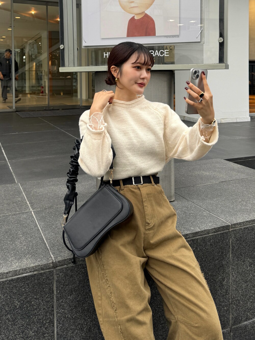 ブラウン系のハンドバッグ、ホワイト系のニット/セーターを着用したレディースの秋コーディネートの5枚目の写真