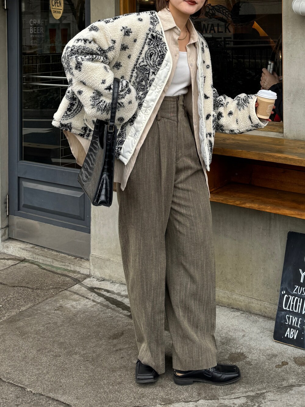 ブラウン系のパンツ、ホワイト系のタンクトップを着用したレディースの冬コーディネートの2枚目の写真