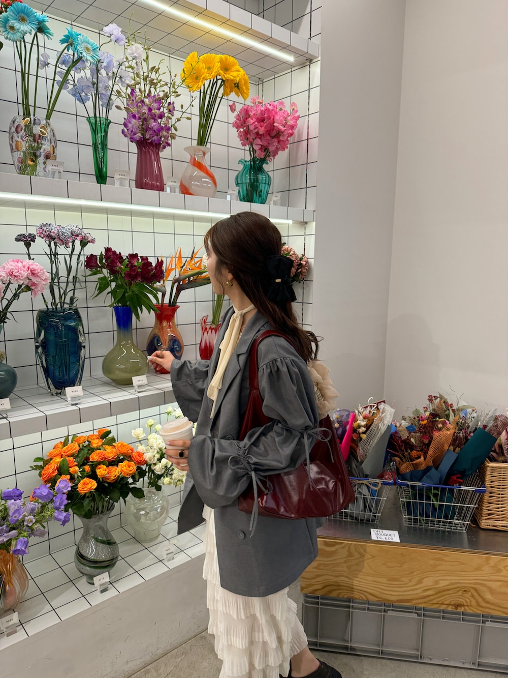 グレー系のテーラードジャケット、レッド系のショルダーバッグを着用したレディースの冬コーディネートの4枚目の写真