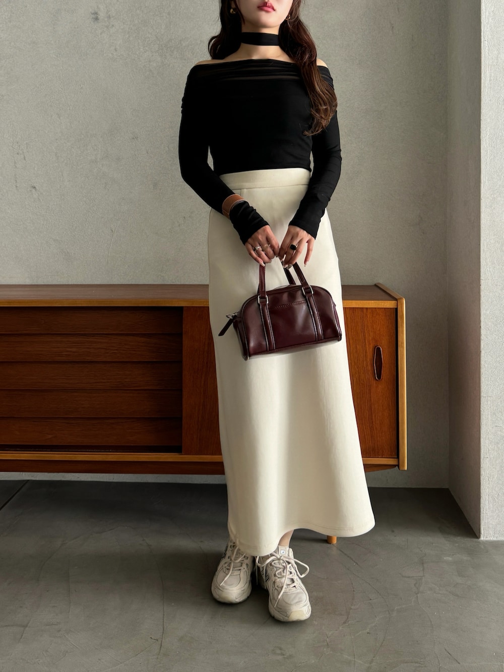 ブラック系のTシャツ/カットソー、ベージュ系のスニーカー、レッド系のショルダーバッグを着用したレディースの春コーディネートの2枚目の写真