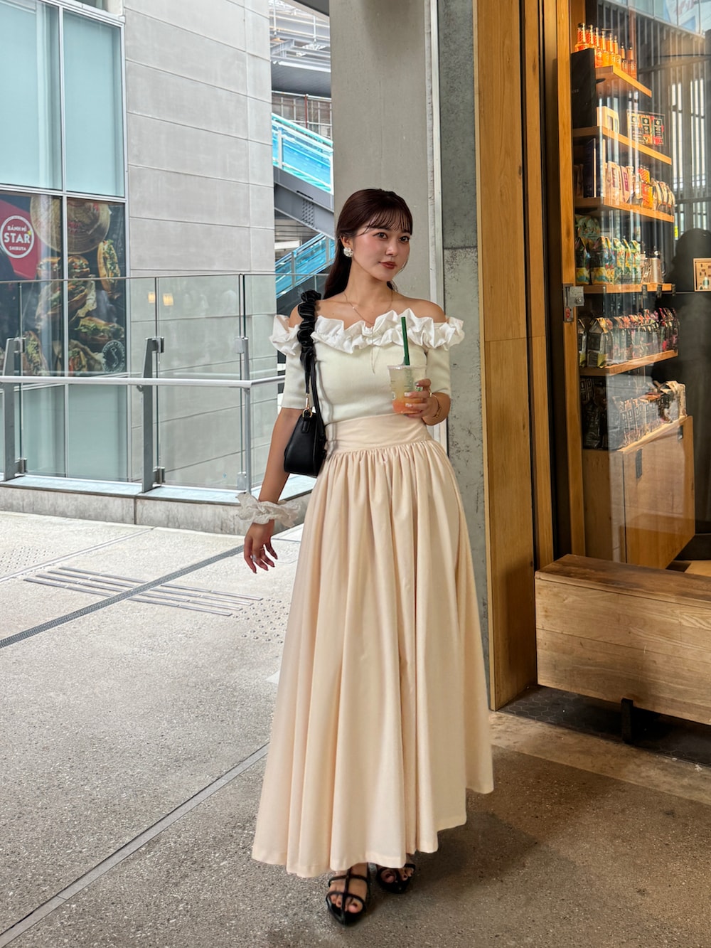 ベージュ系のスカート、ブラック系のサンダル、ホワイト系のニット/セーターを着用したレディースの秋コーディネートの2枚目の写真