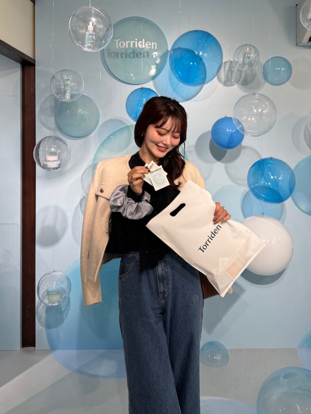 ブルー系のデニムパンツ、シルバー系のパンプス、ブラック系のシャツ/ブラウスを着用したレディースの秋コーディネートの3枚目の写真