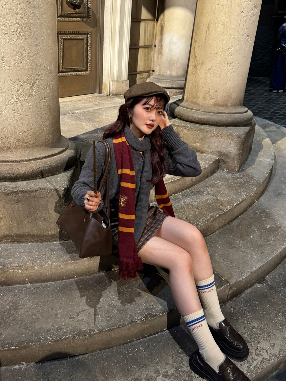 グレー系のニット/セーター、ブラウン系のスカートを着用したレディースの秋コーディネートの3枚目の写真