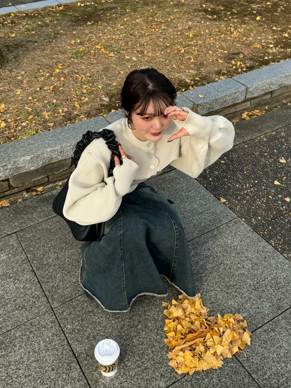 ブラウン系のハンドバッグ、ホワイト系のカーディガン/ボレロを着用したレディースの秋コーディネートの3枚目の写真