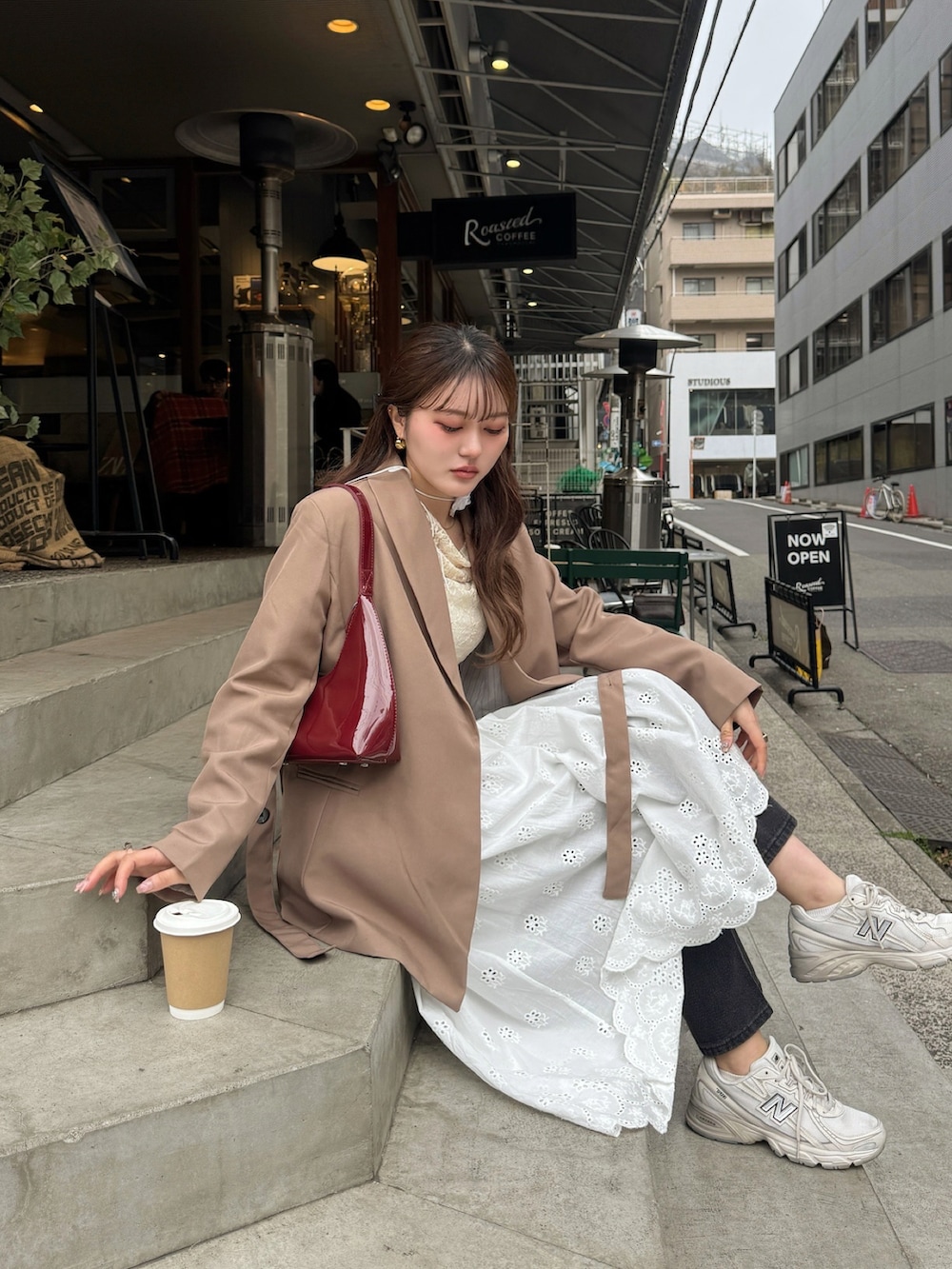 ブラウン系のテーラードジャケット、レッド系のハンドバッグ、ホワイト系のTシャツ/カットソーを着用したレディースの春コーディネートの4枚目の写真