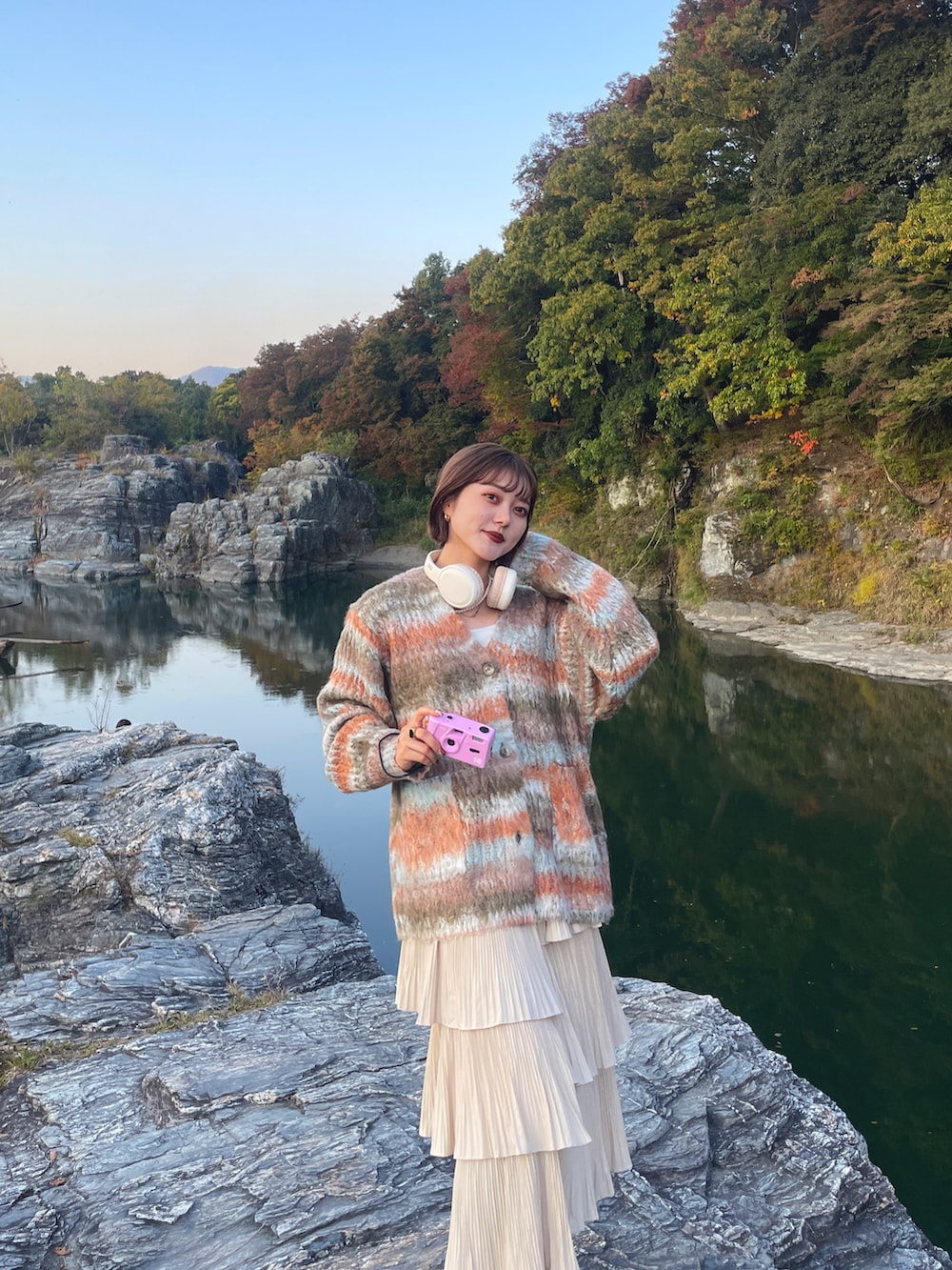 オレンジ系のカーディガン/ボレロ、ブラック系のブーツを着用したレディースの春コーディネートの3枚目の写真